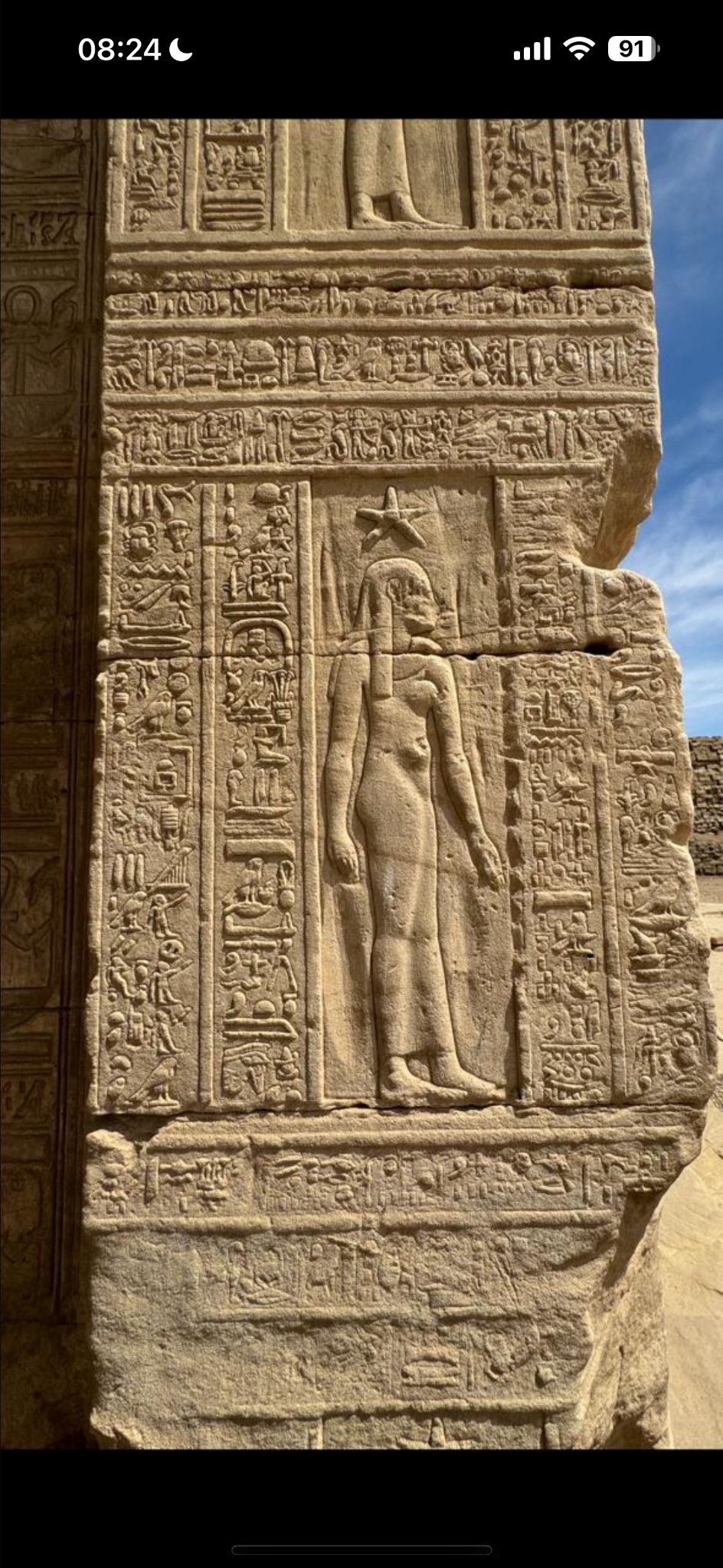 Ancient Egyptian goddess relief surrounded by hieroglyphs